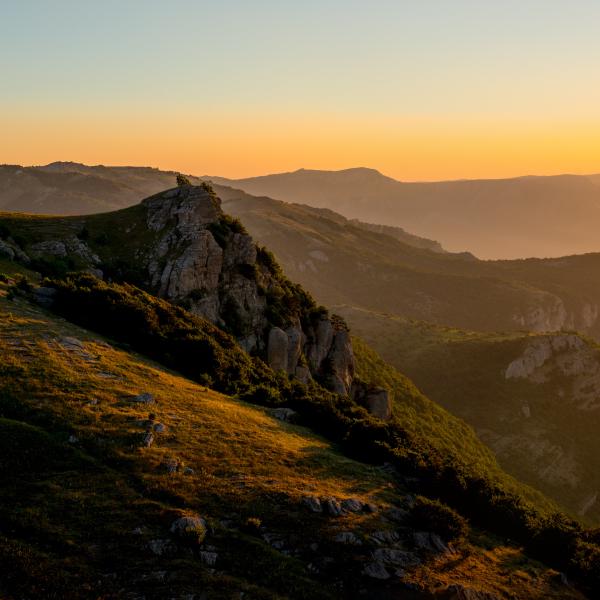 Parapente en Ardèche au coucher de soleil, vol au-dessus de montagnes et paysages naturels préservés, activité sportive et aventure en plein air.